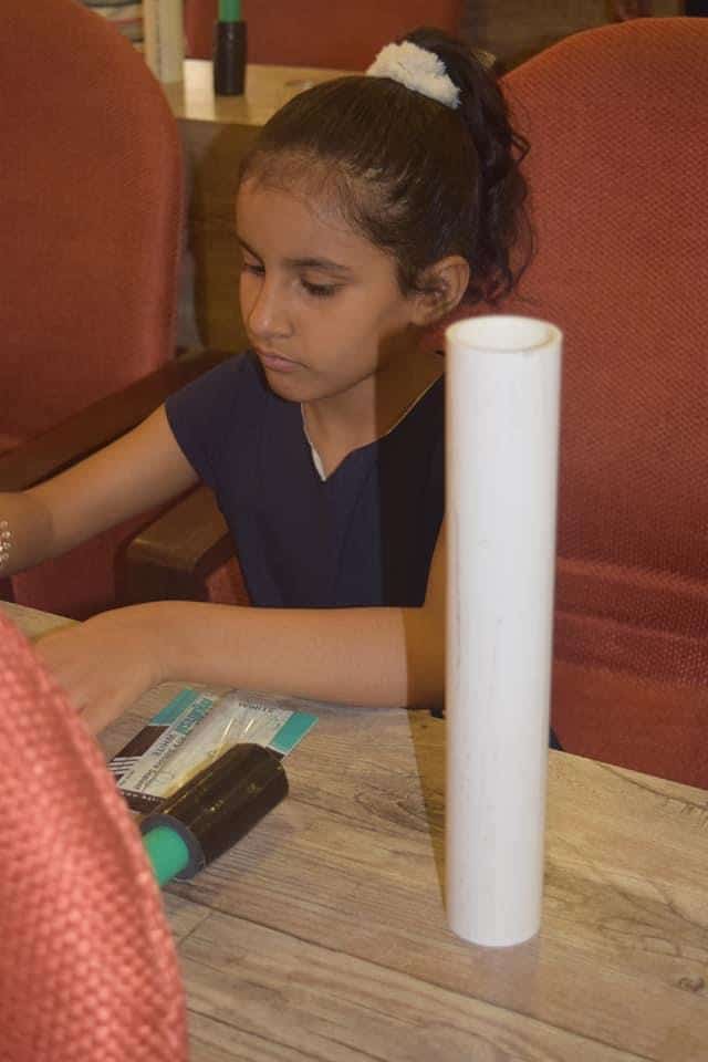 Girl crafting telescope model